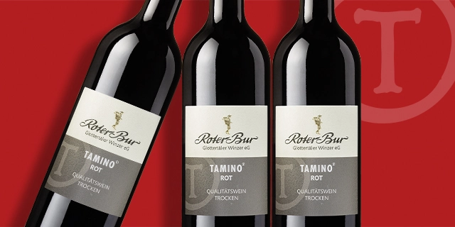 Drei Flaschen Roter Bur Tamino Rot-Rotwein vor rotem Hintergrund. Drei Flaschen Roter Bur Tamino Rot-Rotwein vor rotem Hintergrund.